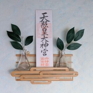 Compact modern wall-mounted Kamidana made of delicate vertical bamboo sticks and a cedar base, featuring a carved bamboo cloud motif.