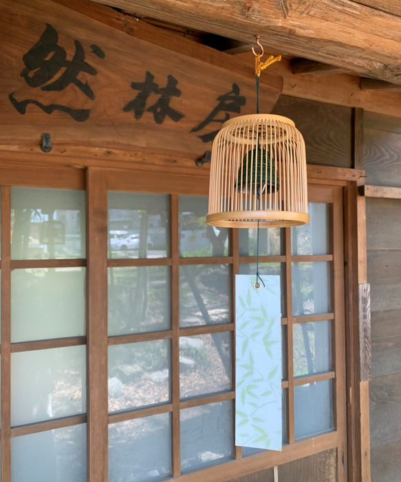 A delicately woven Suruga bamboo wind chime dome inspired by a Komuso monk's basket hat, containing a black Nambu iron bell. – view 2