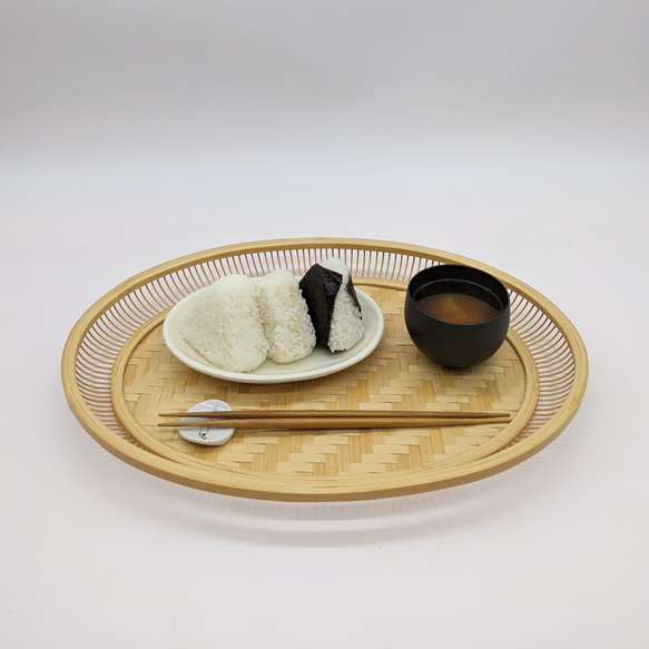 A hand-woven oval bamboo serving tray in natural beige, displaying traditional Japanese ajiro wickerwork on the base and smooth rounded bamboo curves. – view 9