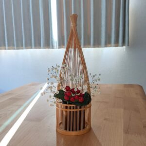 Handmade Suruga bamboo flower vase shaped like bundled straw, standing elegantly with its detailed patterns on its woven base