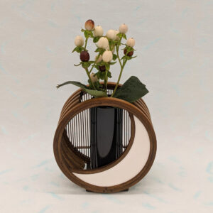 A crescent moon-shaped bamboo flower vase featuring a blend of traditional woven bamboo splints and modern white leather detailing.