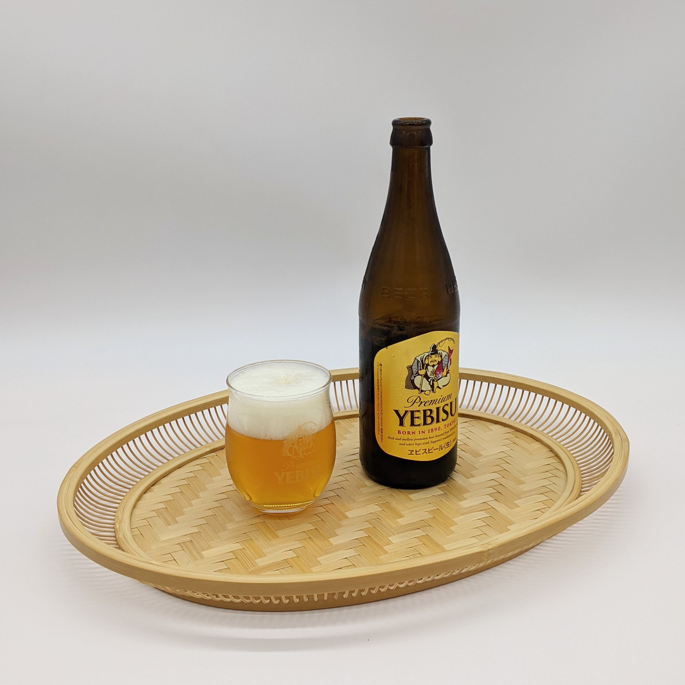 A hand-woven oval bamboo serving tray in natural beige, displaying traditional Japanese ajiro wickerwork on the base and smooth rounded bamboo curves.