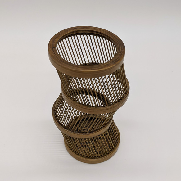 A hand-bent sepia Suruga bamboo single-flower vase with a unique undulating curve, intricate weaving at the base, and an accompanying dark wood stand. – view 7