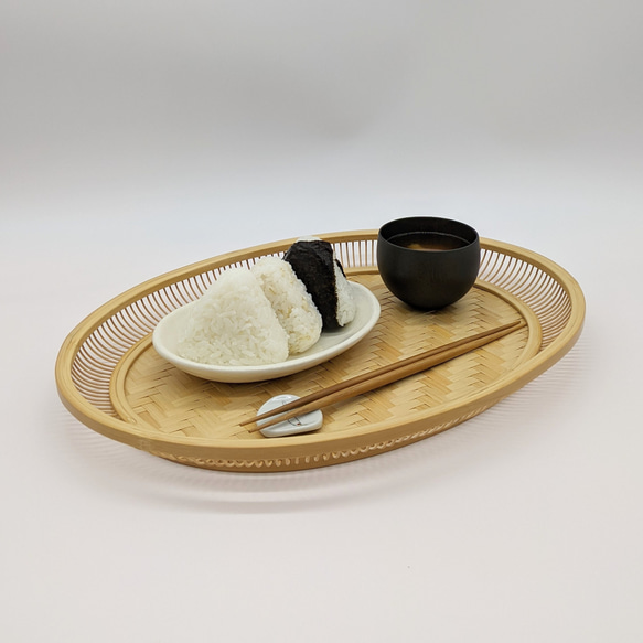 A hand-woven oval bamboo serving tray in natural beige, displaying traditional Japanese ajiro wickerwork on the base and smooth rounded bamboo curves. – view 2